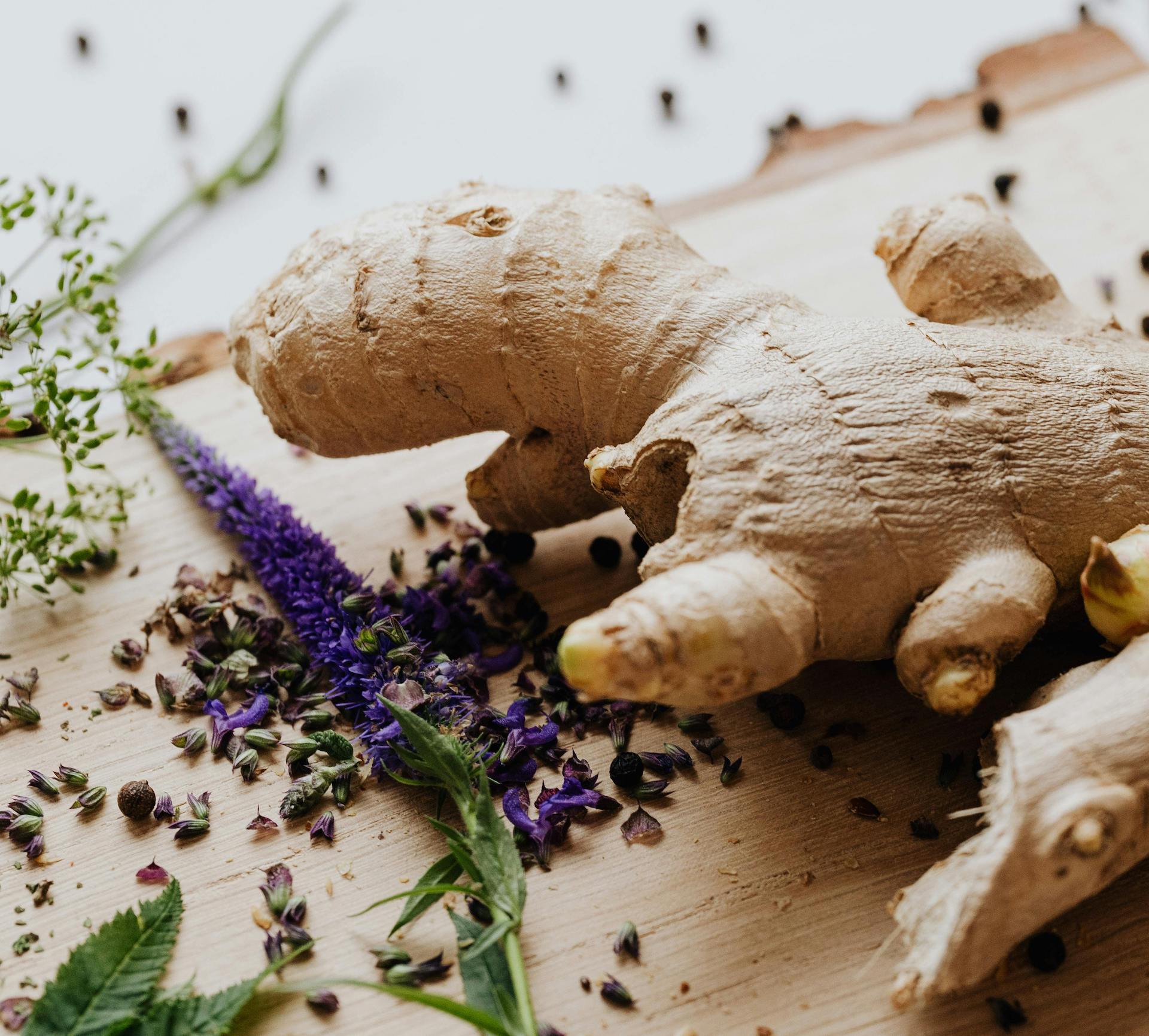 Ginger root on a wooden surface with lavender flowers